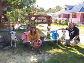 Uma área de jardim com sinalização, mesas ao ar livre e cães.