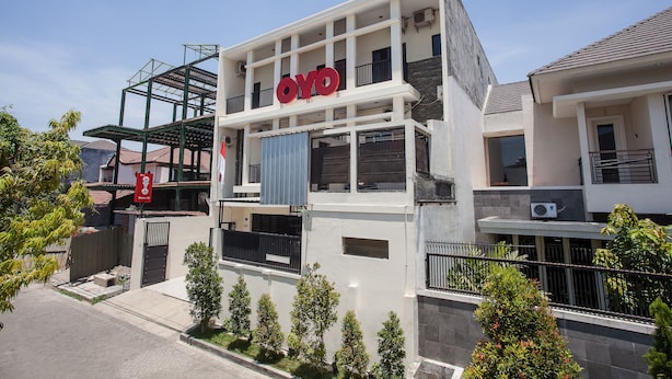 A modern building with a prominent "OYO" sign on the facade, featuring a multi-story structure with balconies and large windows. - Hotel O Graha 99 (Surabaya)
