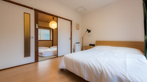 Ett hotellrum med en stor säng, ett sängbord, en lampa och en garderob.