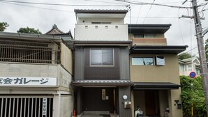 Un bâtiment moderne à deux étages, doté d’une entrée de style traditionnel et d’une enseigne indiquant la présence d’un garage.