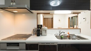 Une cuisine moderne équipée d’un lave-vaisselle, d’un évier et d’un four à micro-ondes.