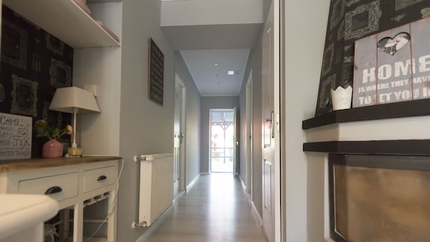 A hallway with a radiator, a lamp, and a sign with a heart and text.