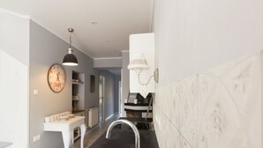 A modern kitchen with a sink, a clock, and a pendant light.