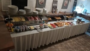 A buffet with various food items and utensils.