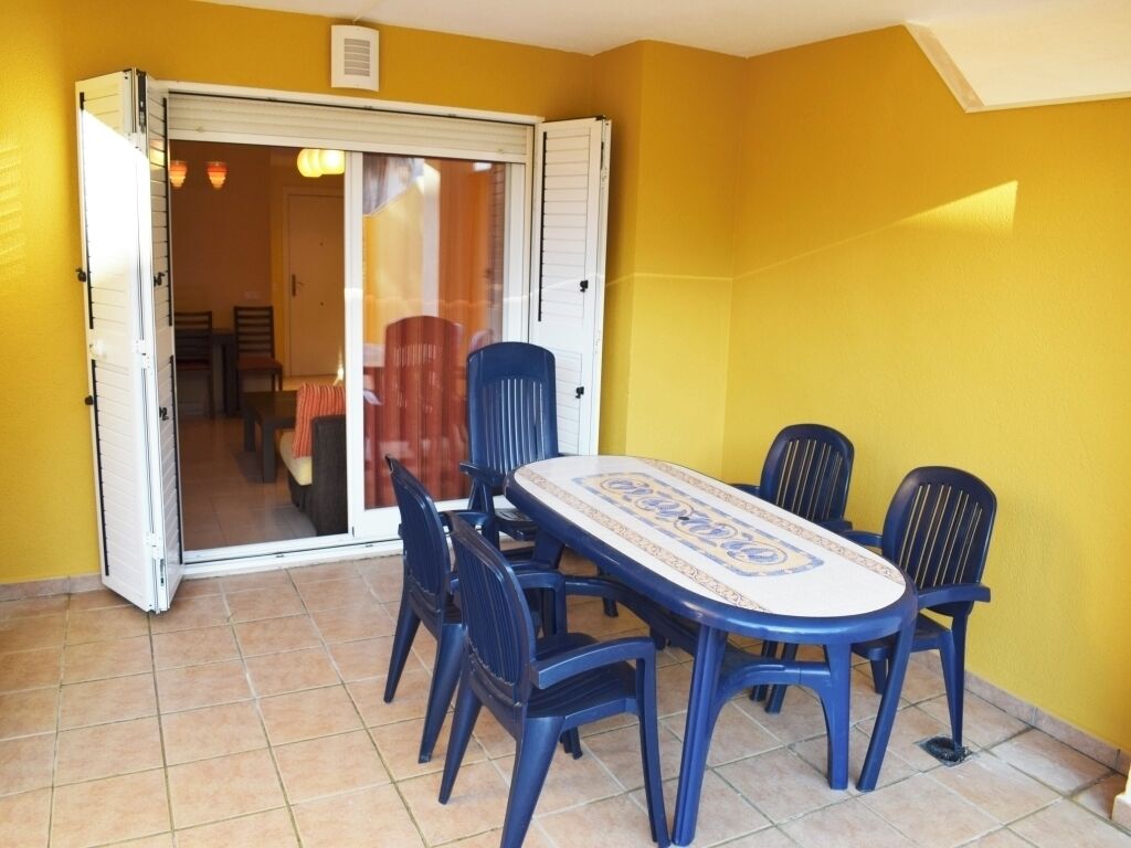 A dining area with a table and chairs, a sliding glass door, and yellow walls.
