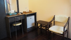 A compact room with a dark wooden desk, a small white refrigerator, a chair, and a mirror. - Kenting Sea Cloudless Day Home (Hengchun)