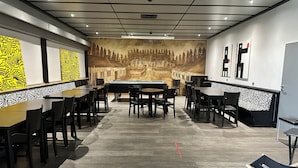 A billiards room with tables and chairs, a pool table, and a mural on the wall. - an Hotel (Selm)