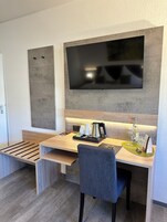 Una cocina moderna con un televisor de pantalla plana grande montado en la pared, encimeras de madera y un banco empotrado con espacio de almacenamiento.