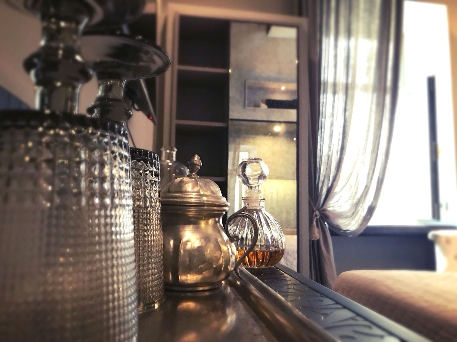 Una mesa con diferentes vasos y recipientes de metal, probablemente usados para servir bebidas.
