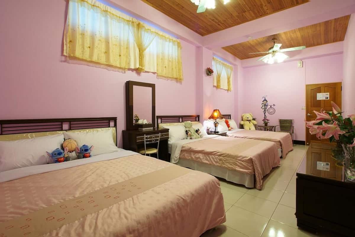 Habitación de hotel con dos camas, techo de madera y un espejo.
