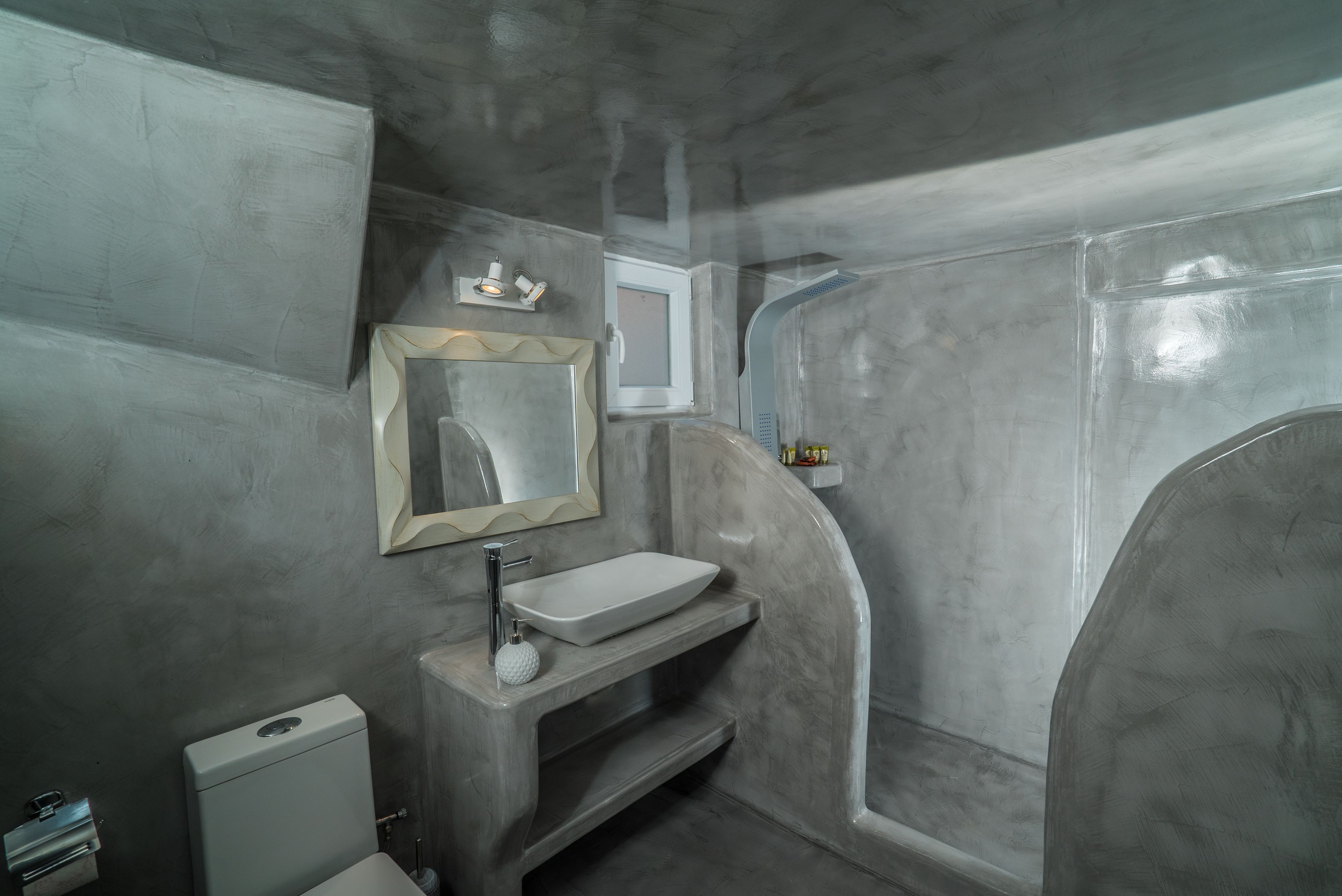 Une salle de bain avec un lavabo blanc, un miroir et une douche.