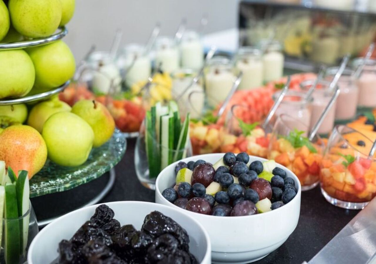 A buffet with various fruits and beverages.