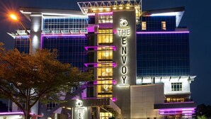 A modern hotel with a prominent vertical sign reading "THE ENVOY." - The Envoy Hotel (Abuja)
