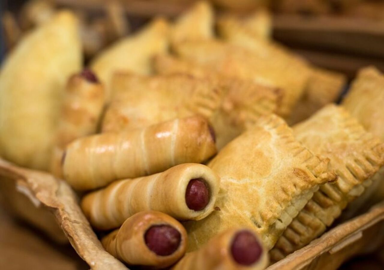 A basket of pastries, including some with sausage inside.