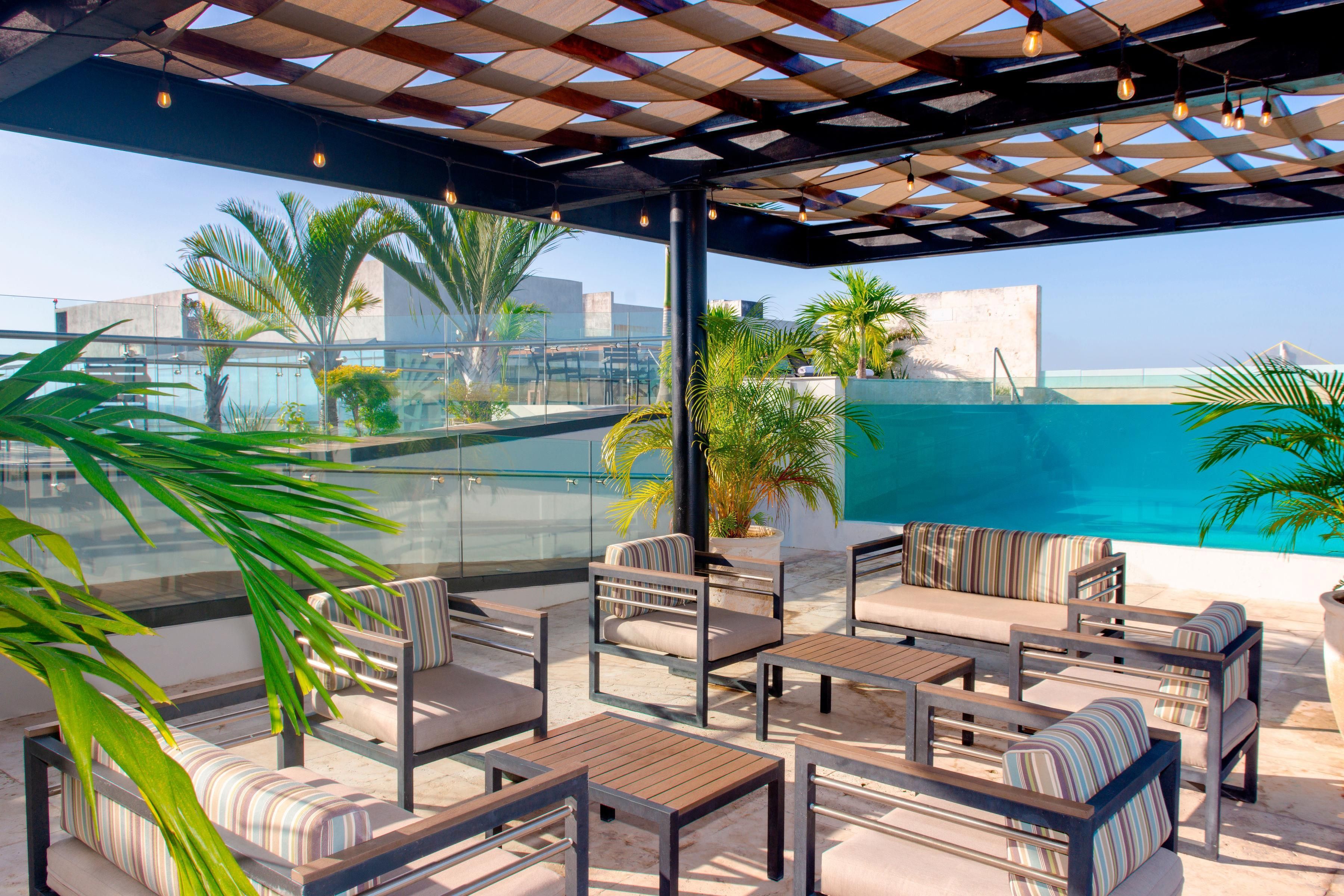 Une terrasse sur le toit avec une piscine, un espace salon et une vue sur la ville.