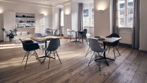 Ein Essbereich mit Holzböden, modernen Stühlen und einer dekorativen Decke.