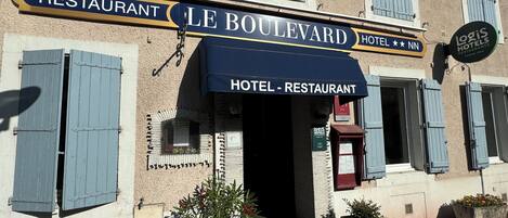 Un edificio con un cartel que dice "LE BOULEVARD HOTEL RESTAURANT" y "Logis Hotels".