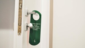 A door with a green sign that reads "PLEASE MAKE UP ROOM" in multiple languages. - Olivia Rooms Eurialo (Syracuse)