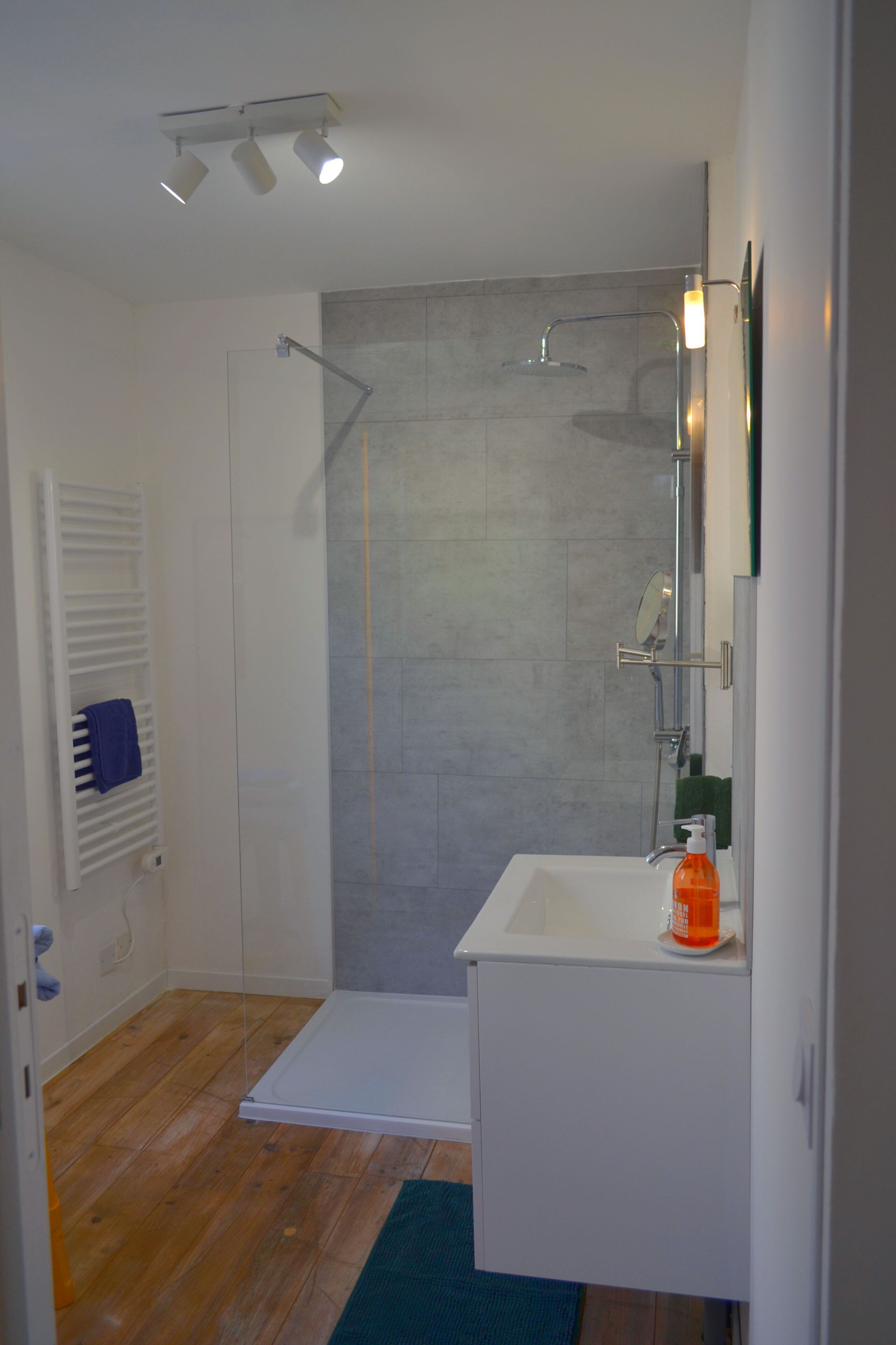 Un bagno con doccia, lavandino e specchio.