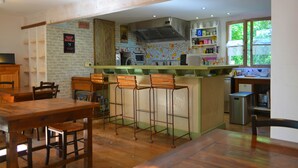 Un restaurante acogedor con una decoración rústica, que incluye muebles de madera y una zona de bar.