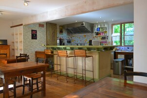 Um restaurante acolhedor com decoração rústica, com móveis de madeira e um espaço de bar.