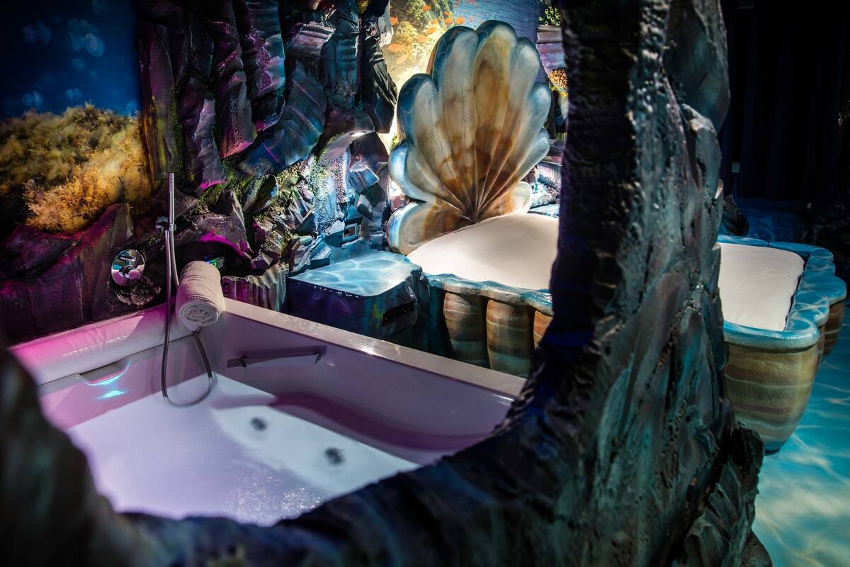 A bathtub in a room with a rocky, cave-like interior.