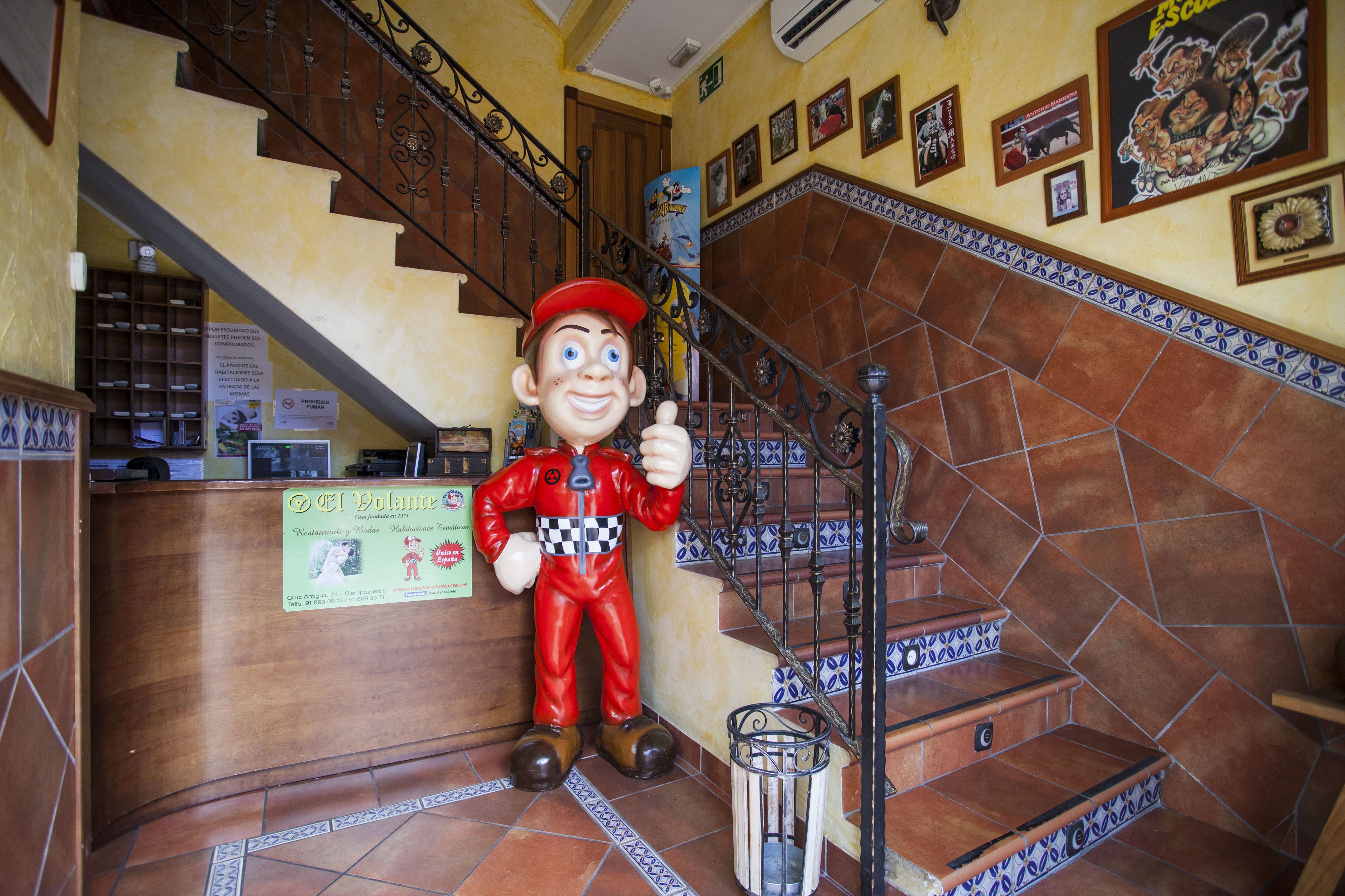Eine Treppe mit einer großen Maskottchenfigur, einem Mülleimer und einem Schild.