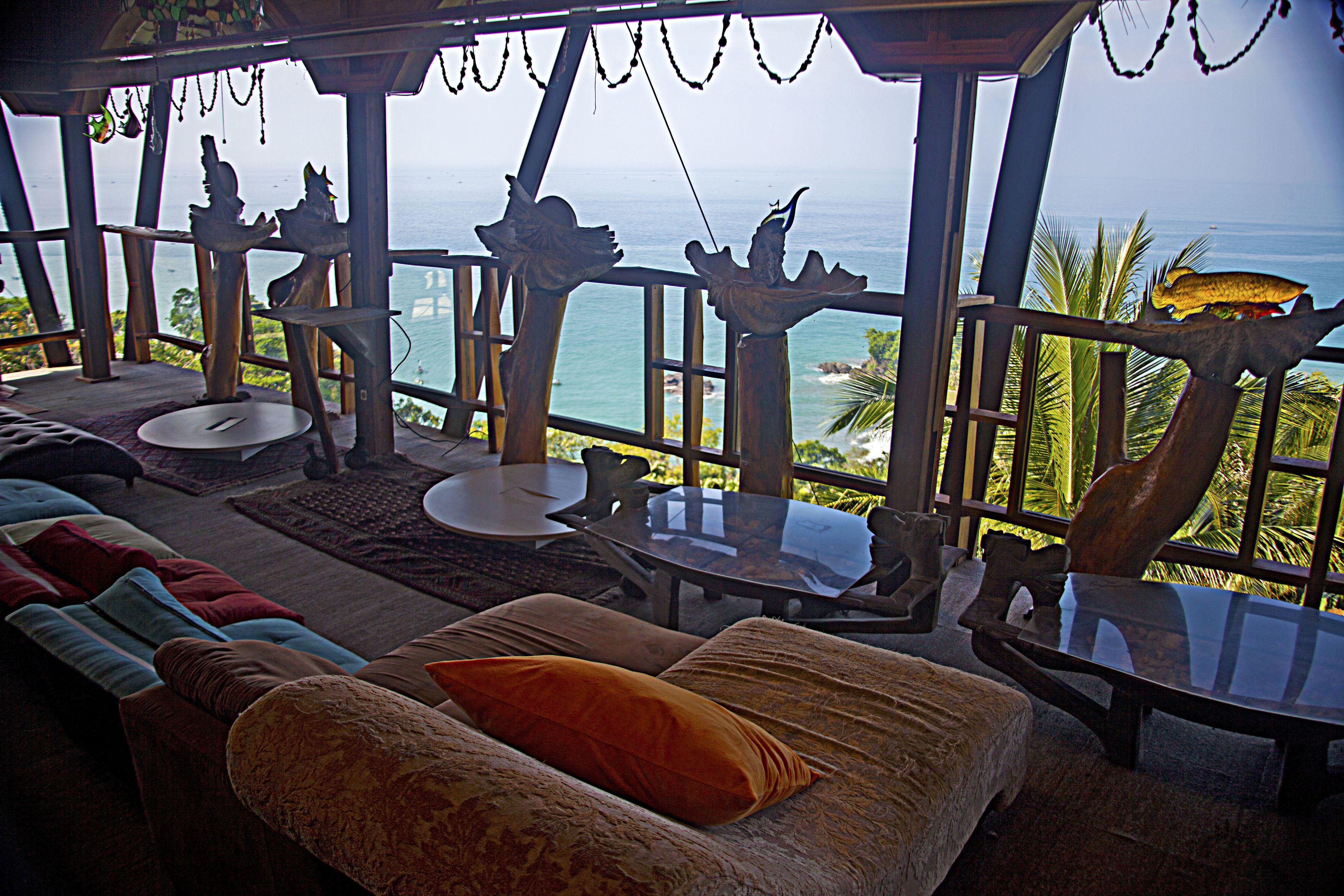 Cómoda zona de estar con vista al océano, que incluye un sofá, una mesa y detalles de madera decorativa.