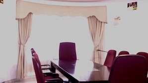 A room with a dining table, chairs, and curtains. - LTN Lodge (Johannesburg)