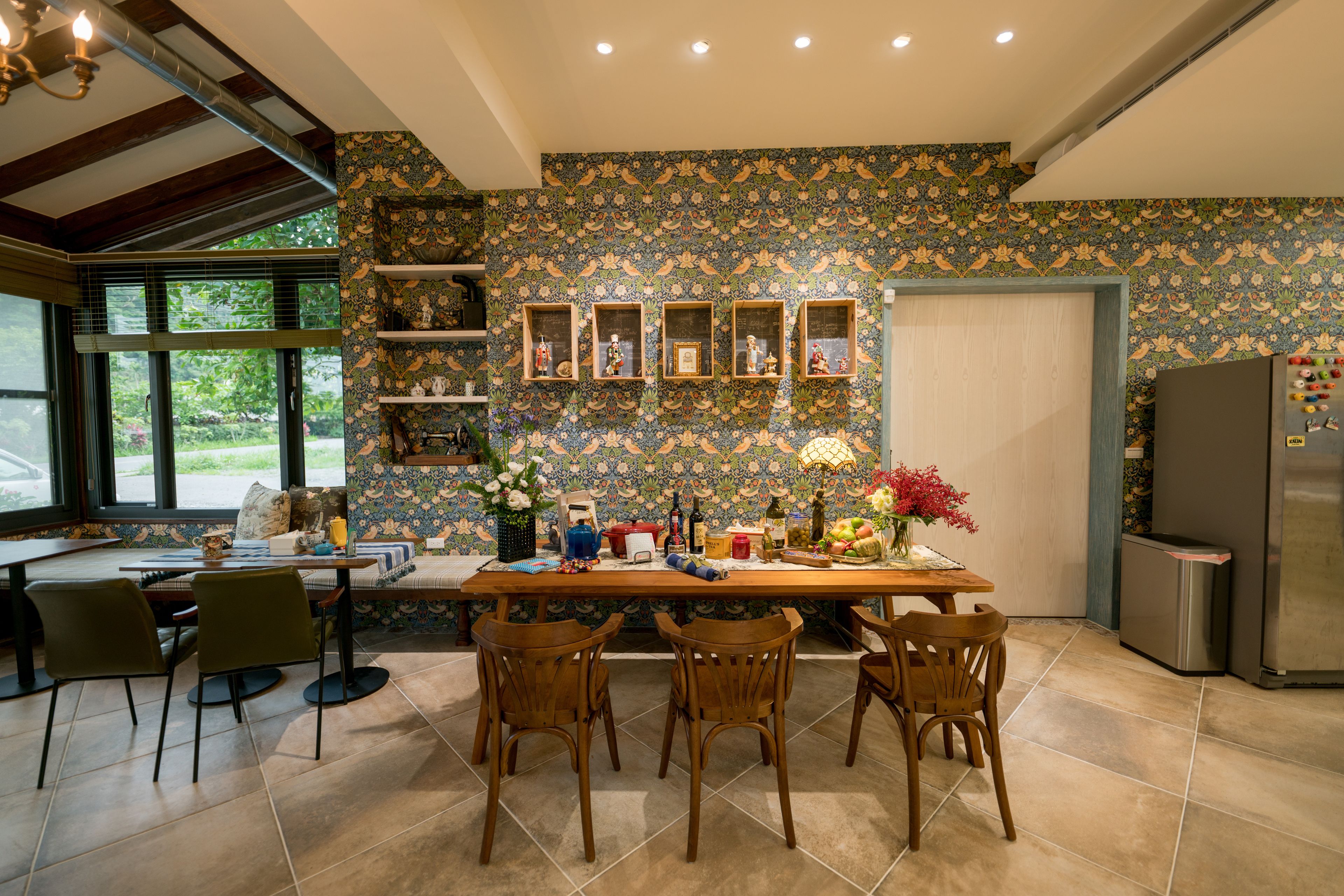 Una cocina con una mesa de madera, sillas y un refrigerador.