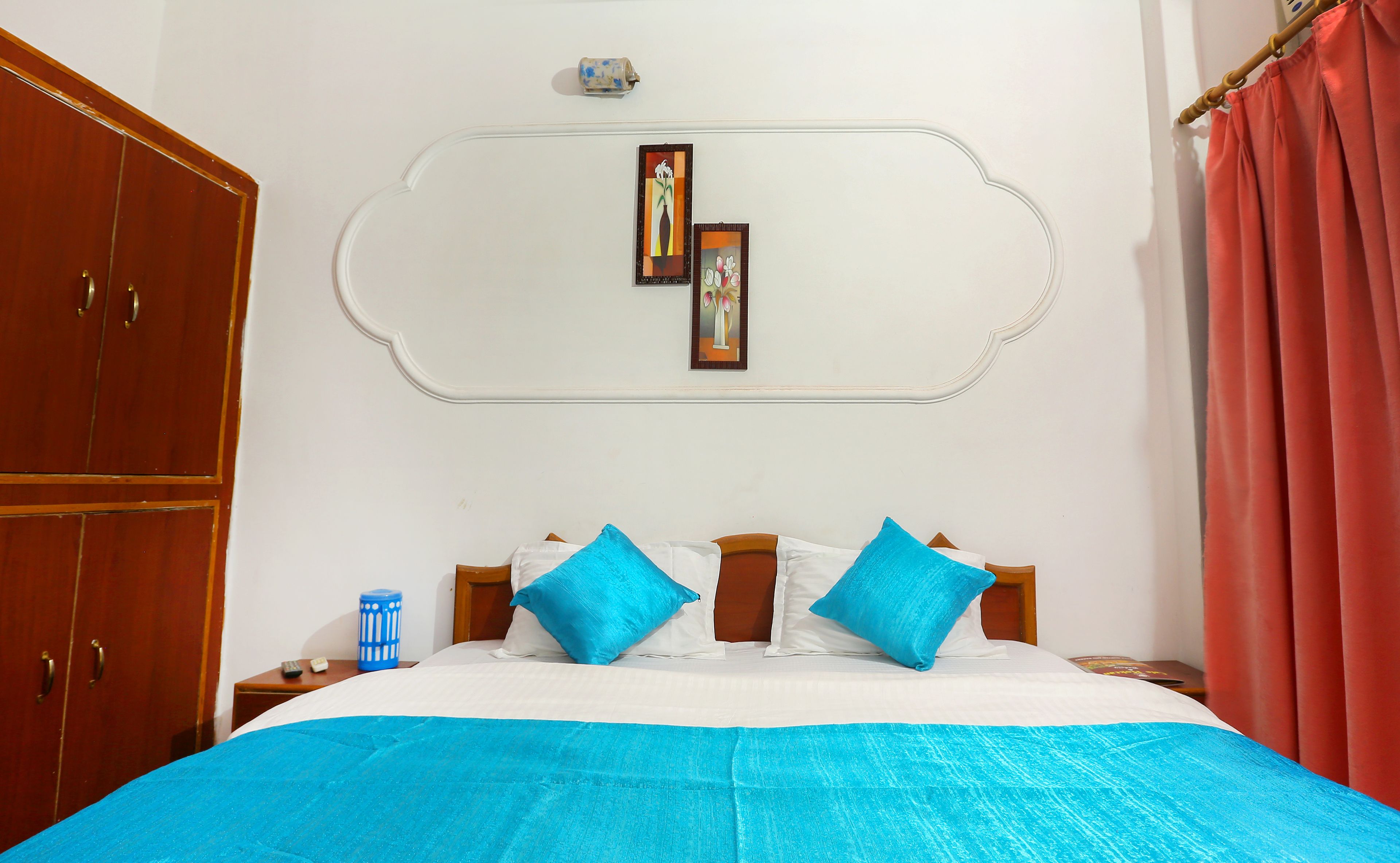 Un dormitorio con cama, armario, mesita de noche y un adorno en la pared.