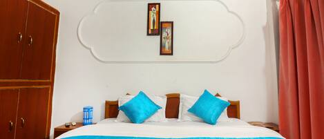 Un dormitorio con cama, armario, mesita de noche y un adorno en la pared.