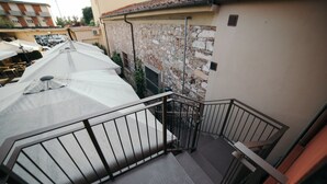 A staircase with metal railings leading to a terrace area with umbrellas. - Garage Bonci B&B (Pietrasanta)