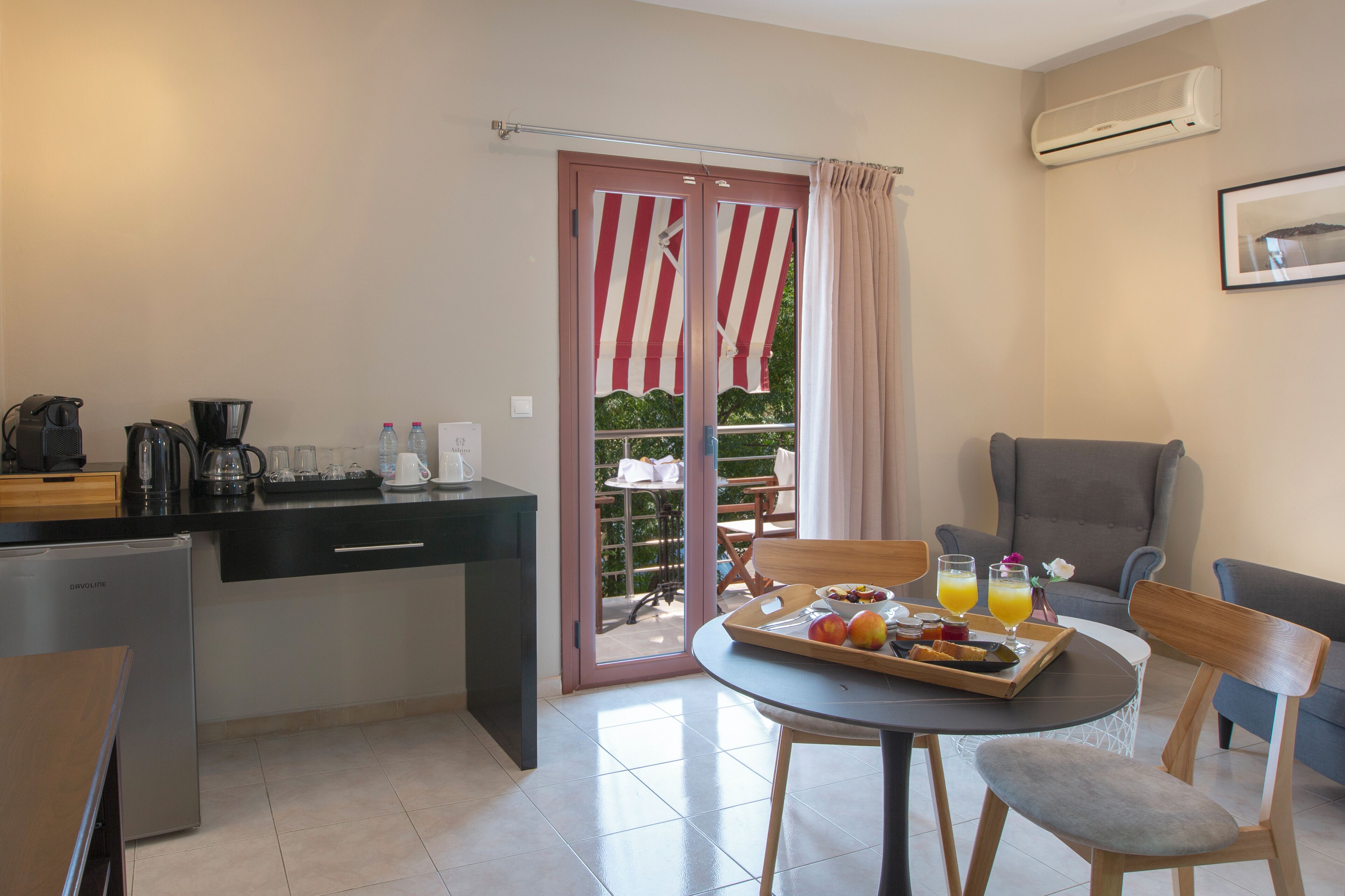 A compact kitchen with a refrigerator, coffee maker, and a dining area with a table set for breakfast.