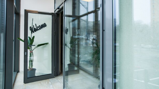 Entrada de un hotel moderno con puerta de vidrio que muestra el texto
