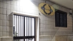 A tiled wall with a barred entrance and a circular sign above it. - Romano b&b (Bari)