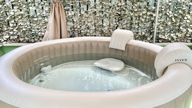 A hot tub with a water heater, a towel, and a chair. - Romano b&b (Bari)
