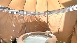 A hot tub inside a tent with a green floor. - Romano b&b (Bari)