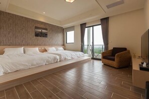 Une chambre d’hôtel spacieuse, dotée d’un grand lit, d’un canapé et d’un balcon avec vue.