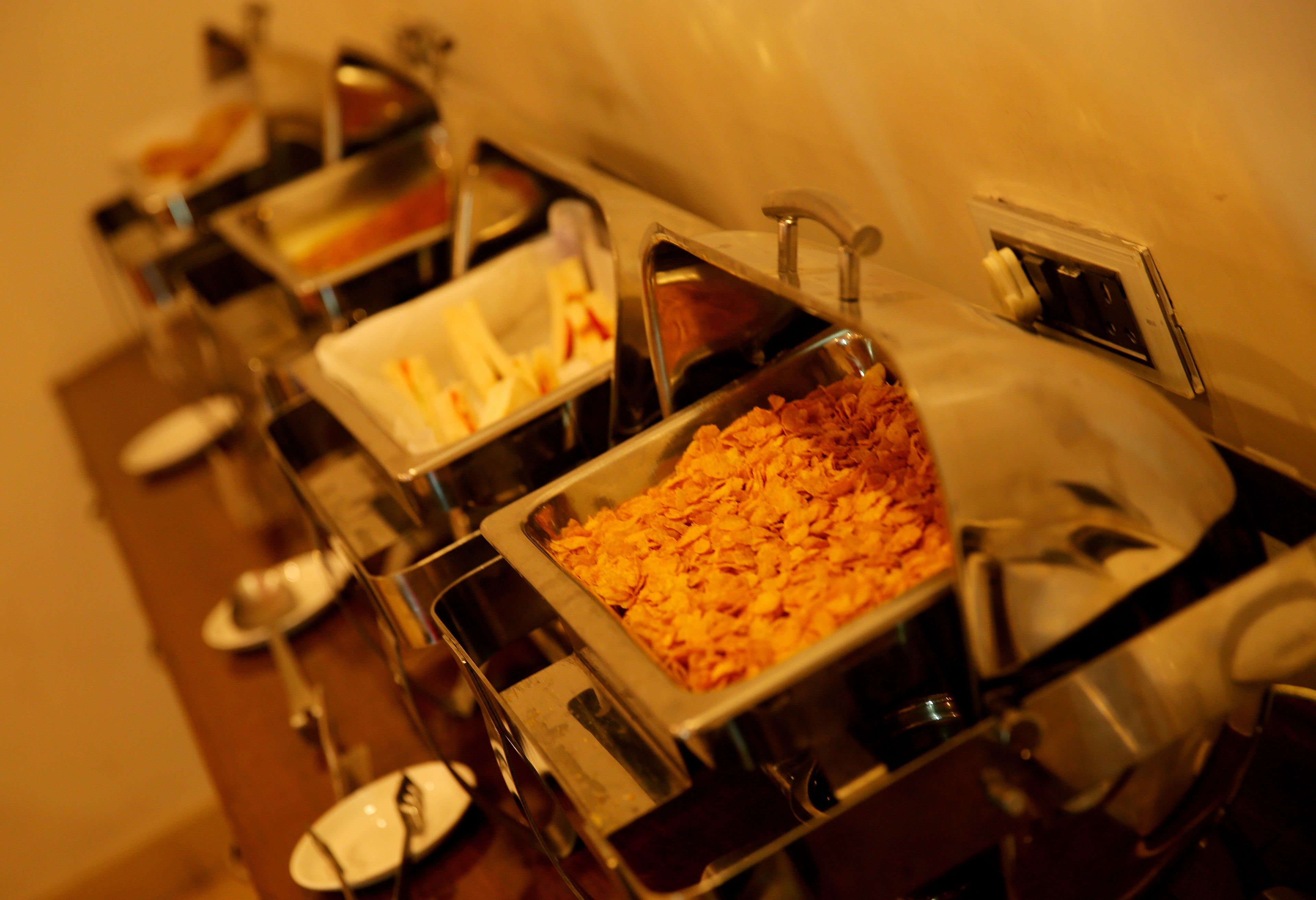 A buffet with various food items and utensils.