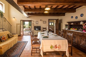 A dining area with a table set for four, a sofa, and a view of the outdoors.