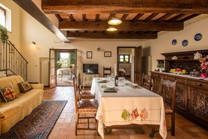Un comedor con una mesa preparada para cuatro, un sofá y vistas al exterior.