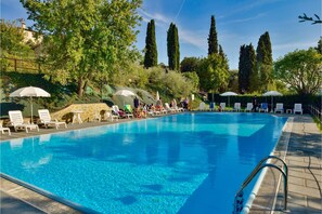 Piscine extérieure, parasols de plage, chaises longues
