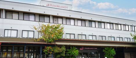 A building with a tiled facade and a sign reading "REMBRANDT".