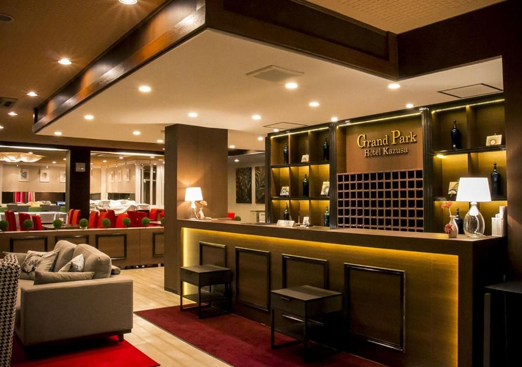 Un vestíbulo de hotel con mostrador de recepción, zona de estar y bar.