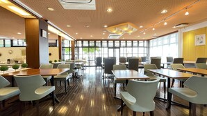 A spacious indoor dining area with wooden tables and chairs, large windows providing natural light, and a modern ceiling design. - REMBRANDT INN KAZUSA (Kimitsu)