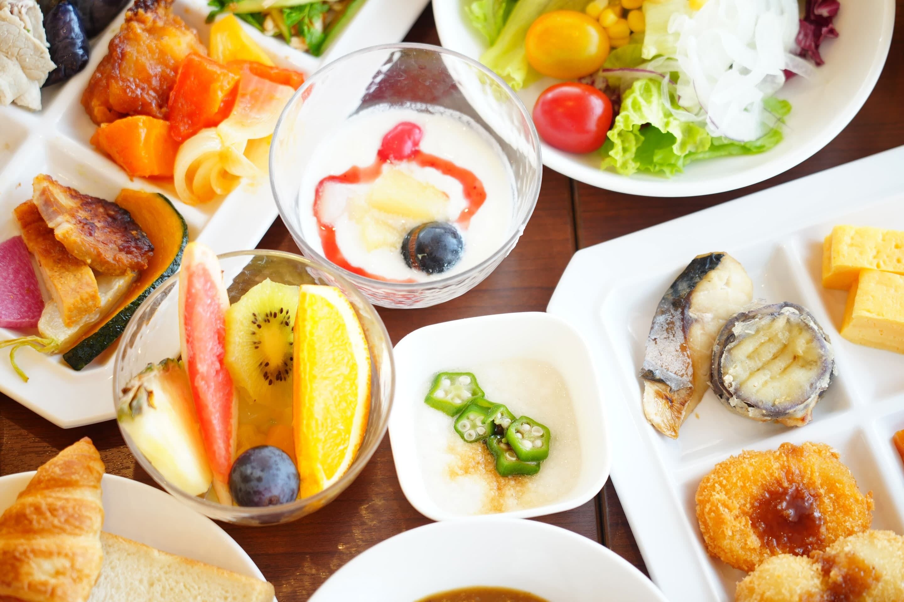 Une variété de plats, notamment des fruits, des légumes et des fruits de mer, sont disposés sur une table.