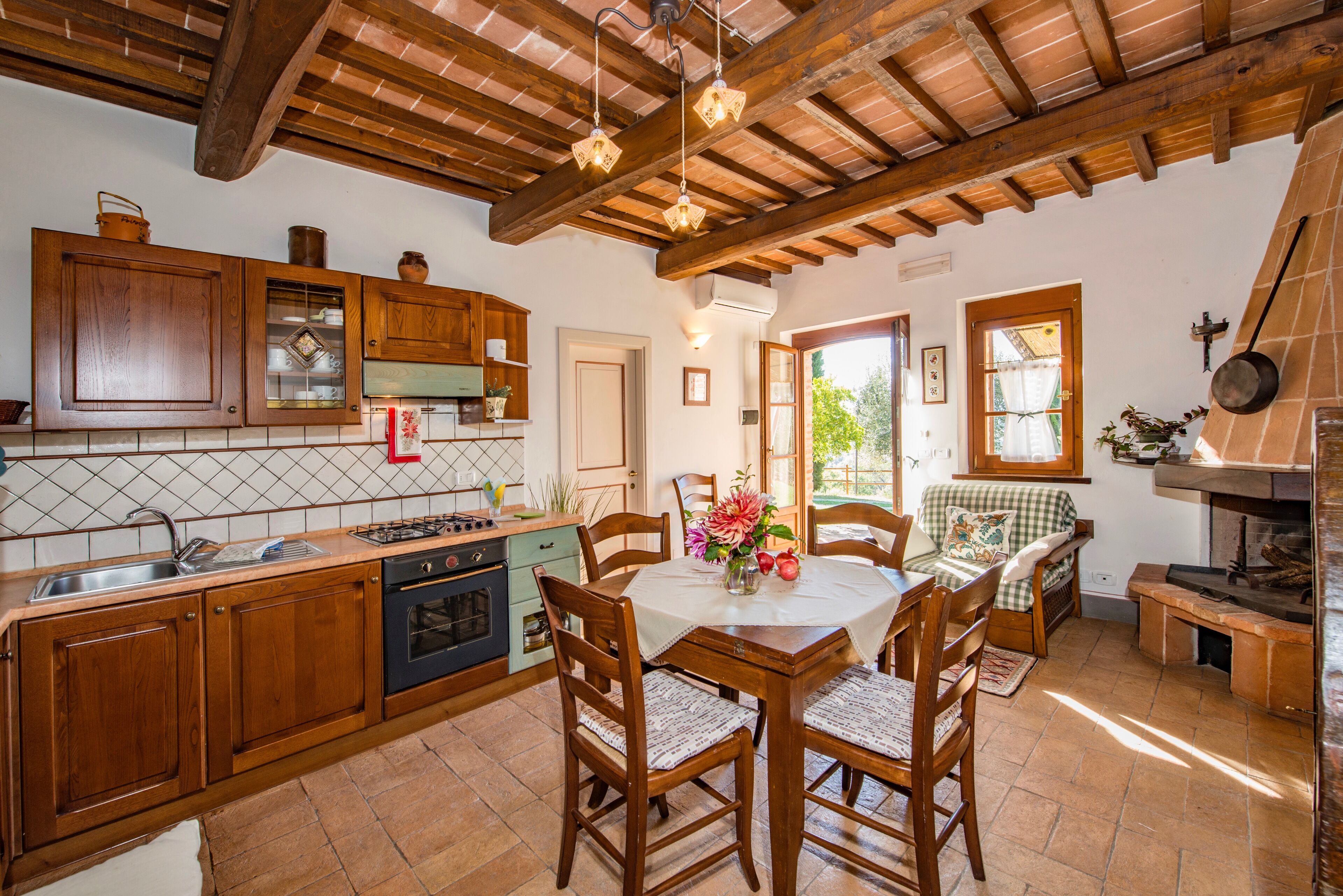 Une cuisine rustique avec des meubles de rangement en bois, une table à manger avec des chaises et une cheminée.
