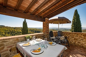 An outdoor dining area with a table set for two, overlooking a scenic landscape. - Agriturismo Malagronda (Citta della Pieve)