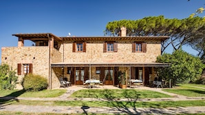 A stone building with a patio area, outdoor seating, and a covered entrance. - Agriturismo Malagronda (Citta della Pieve)
